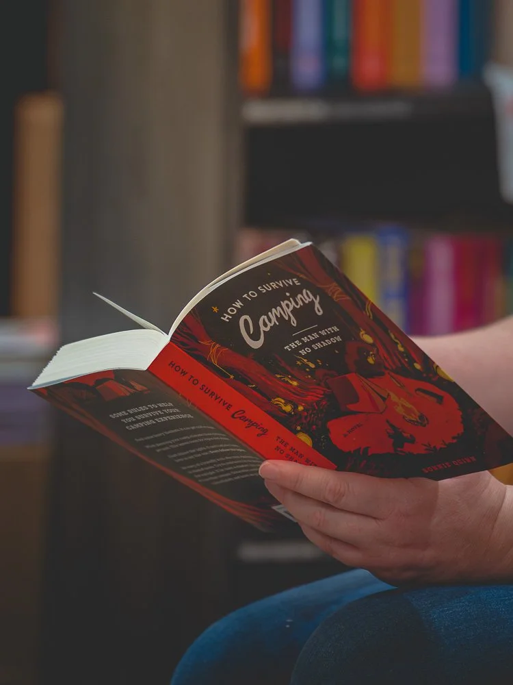 Bonnie Quinn holding a copy of How to Survive Camping during the reading