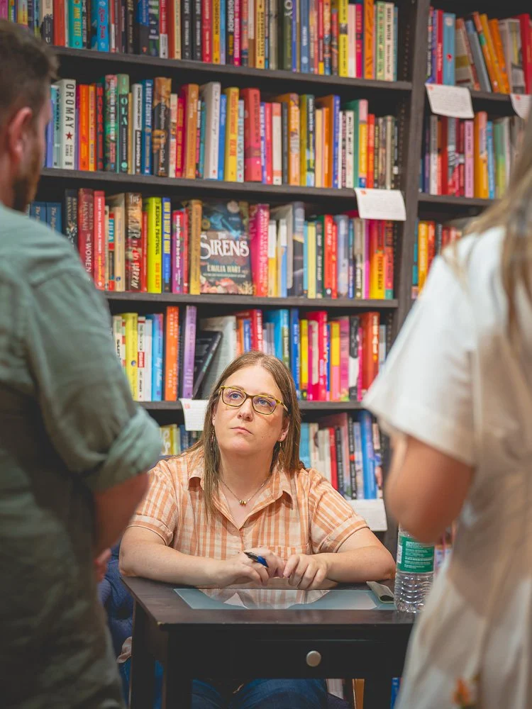 Bonnie Quinn listening to two readers at the signing table