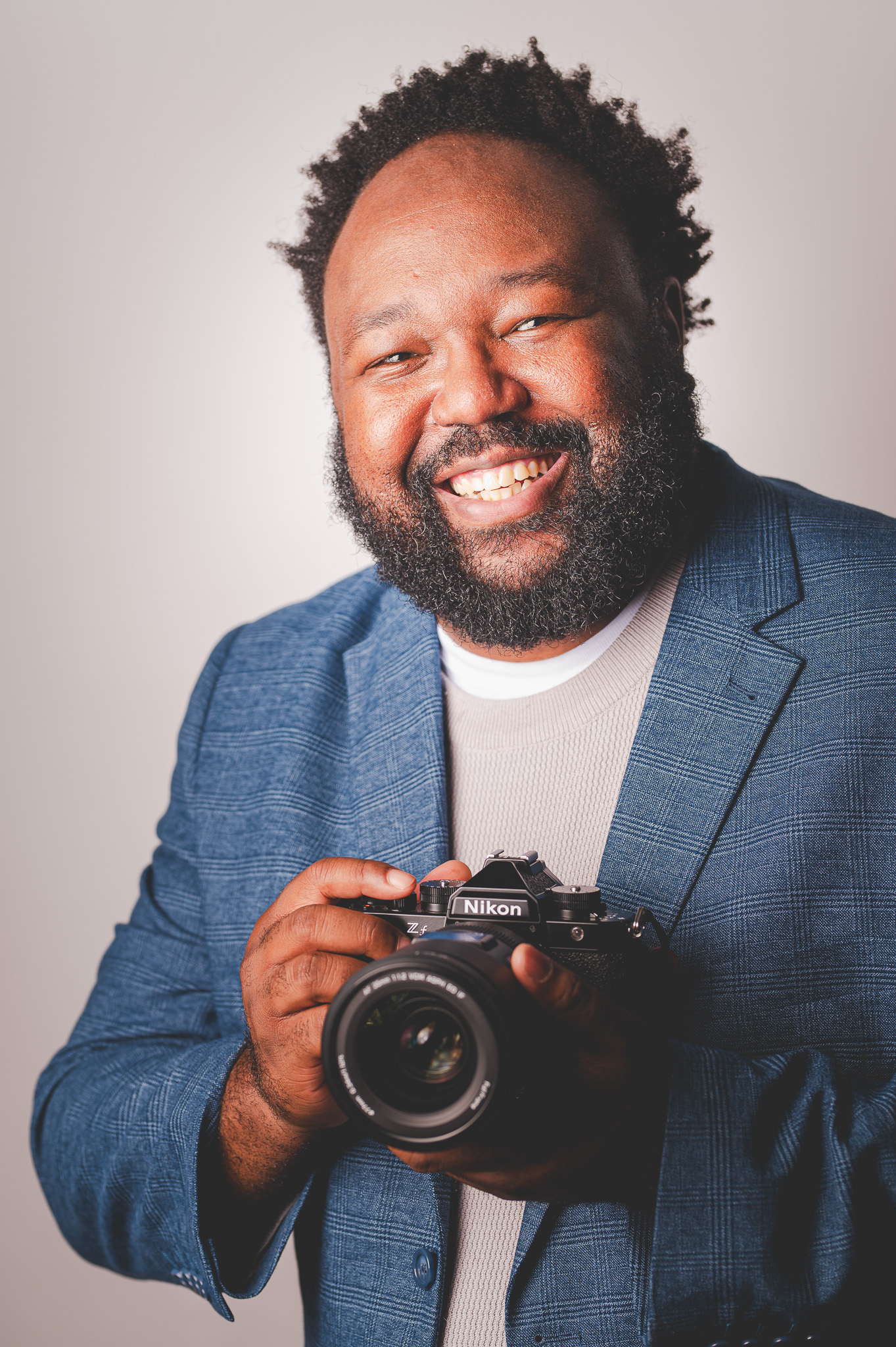 Columbus photographer Glenn Harmon smiling and holding a camera
