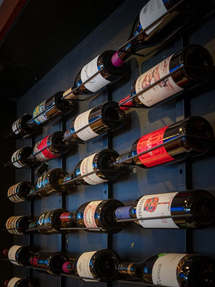 Wine bottles displayed horizontally on a dark wall