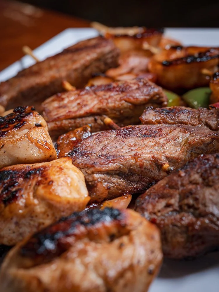 Grilled steak and chicken skewers arranged on a platter