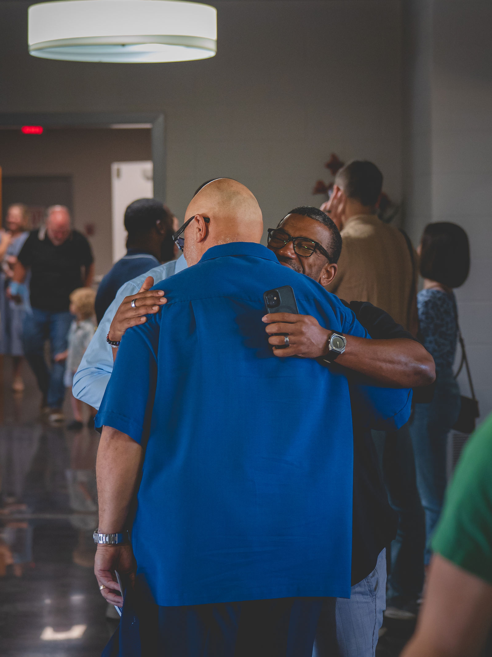 Two Sanctuary Columbus members greeting each other with a hug