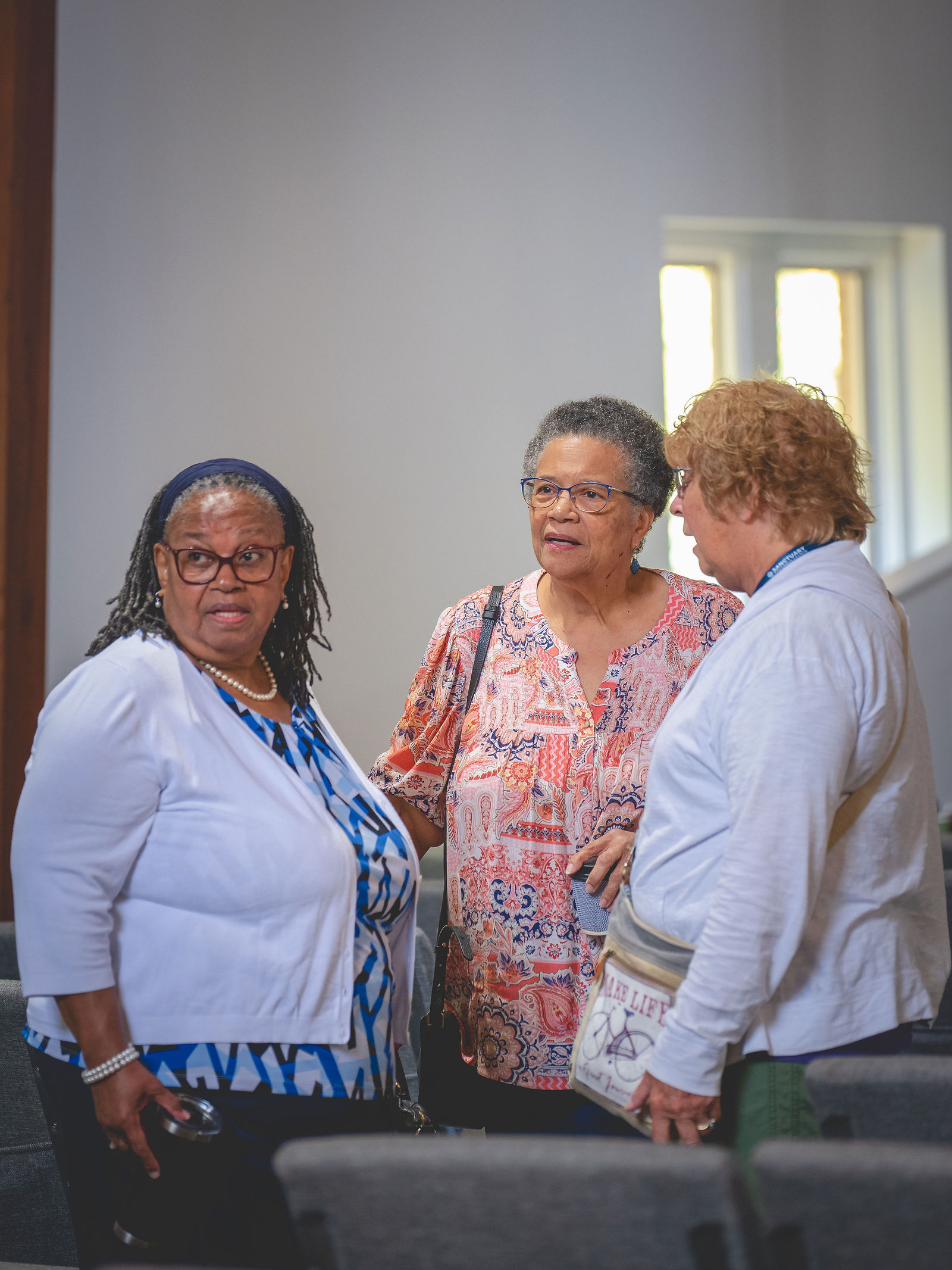 Three members talking together in the Sanctuary Columbus worship space