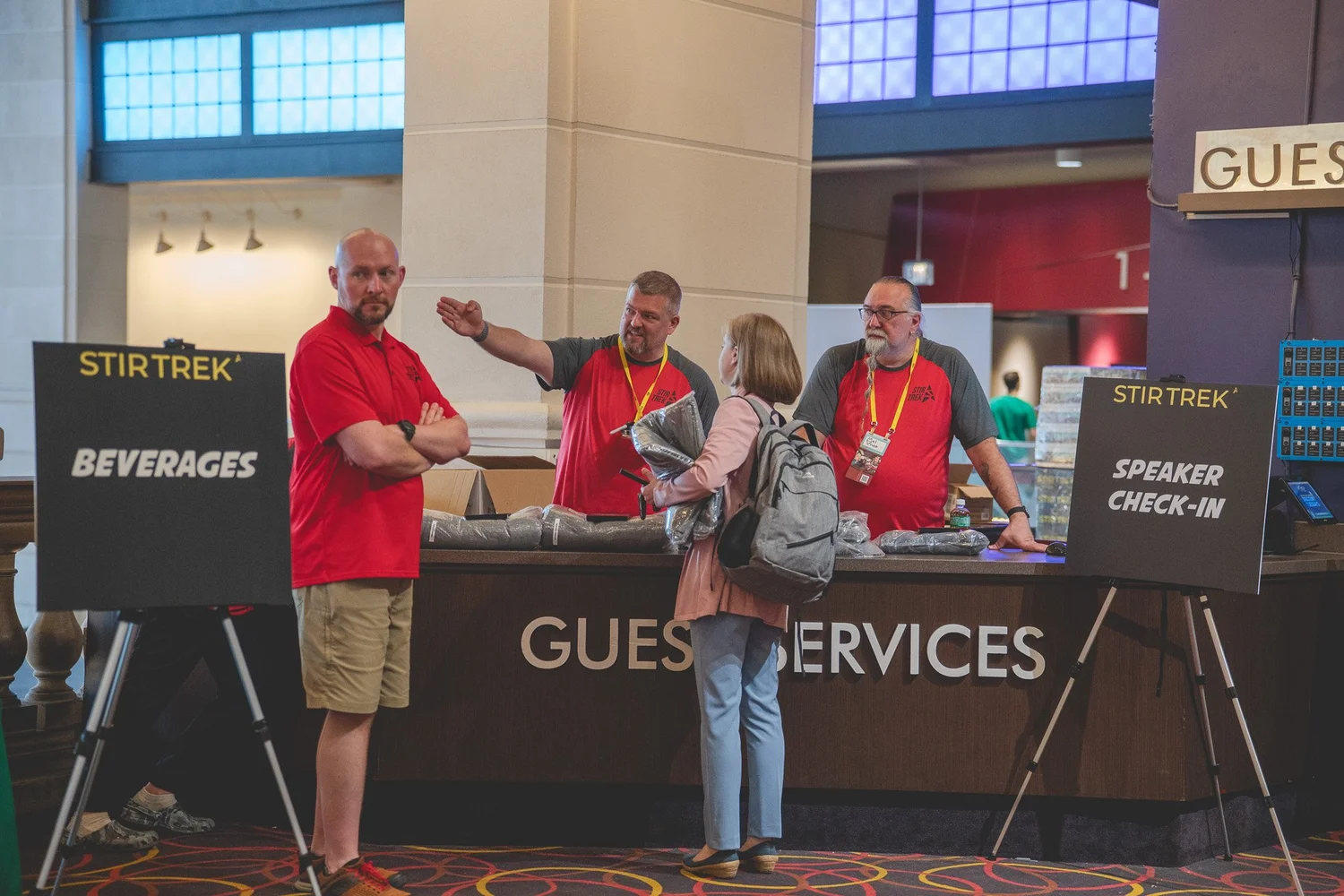 Stir Trek volunteers assisting a speaker at the check-in desk
