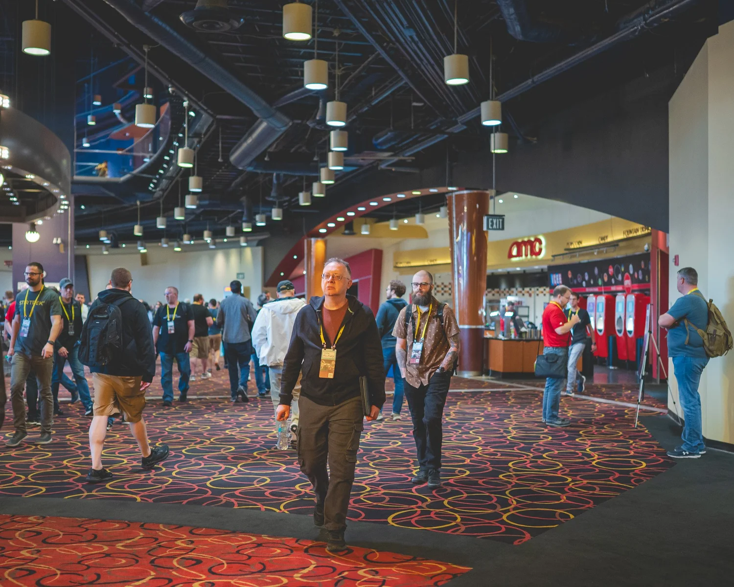 Conference attendees walking and talking in the AMC Easton lobby
